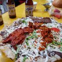 MEX OAX OaxacaDeJuarez 2019APR03 025  My   Tlayuda Mixta   consisted of a large 12-inch partially fried or toasted corn tortilla, covered with a refried beans paste, shredded cabbage, flat iron pork and beef,   Oaxaca cheese  ,   Portuguese Chouriço   ( a type of pork Chorizo sausage ) and a cilantro &amp; chile sauce ...... which sounds like an odd combination, but awesome eating. : - DATE, - PLACES, - TRIPS, 10's, 2019, 2019 - Taco's & Toucan's, Americas, April, Comedor María Alejandra, Day, Mercado 20 de Noviembre, Mexico, Month, North America, Oaxaca, Oaxaca de Juárez, South Pacific Coast, Tlayuda Mixta, Wednesday, Year